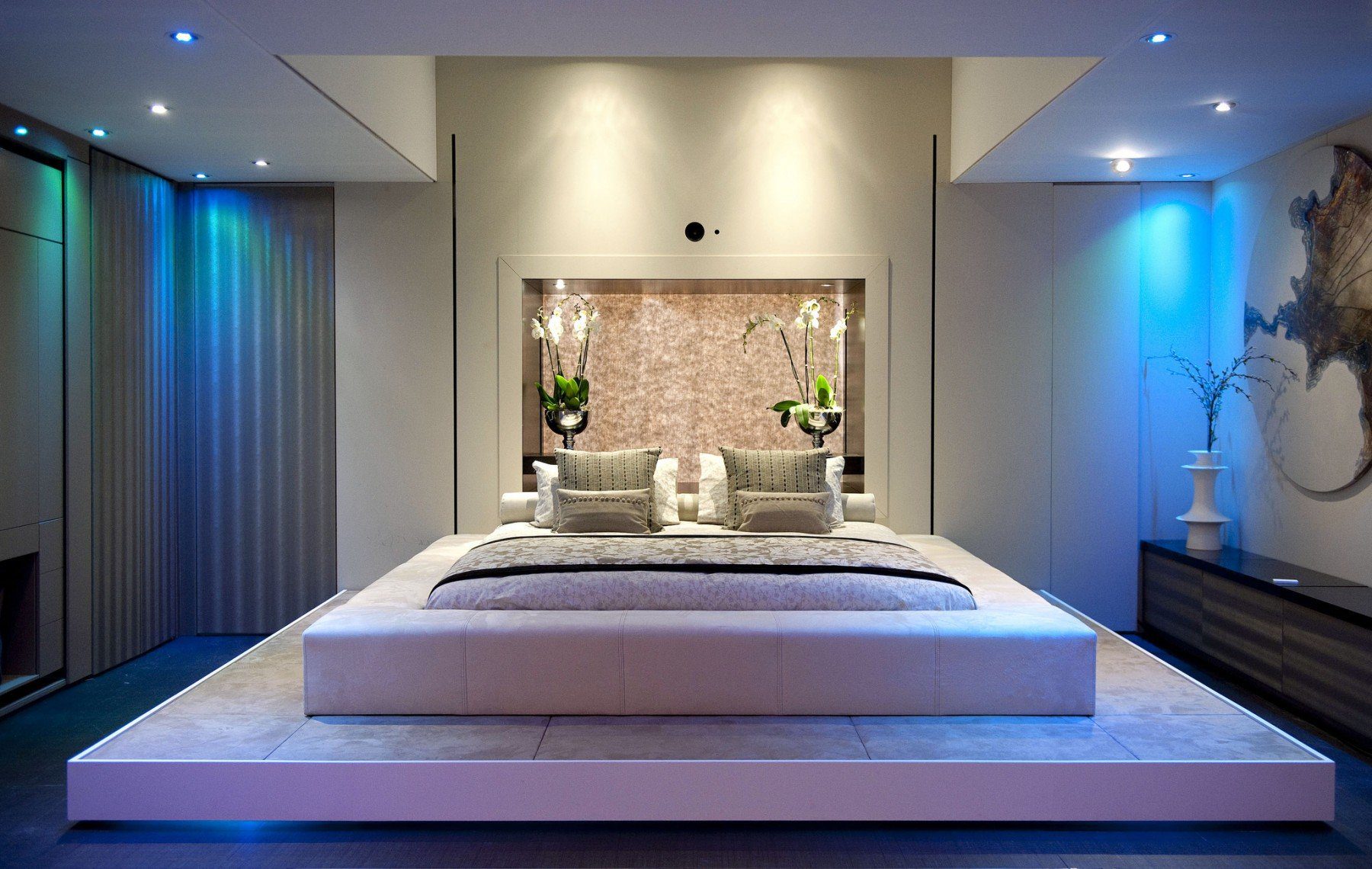 A luxury bedroom with a platform bed and recessed blue lighting, like one might find in a home managed by ACRES Property Management in Seattle